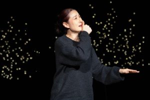 Qi Chunyan från Kina uppträder på scen. Hon tecknar det kinesiska ordet för mamma.