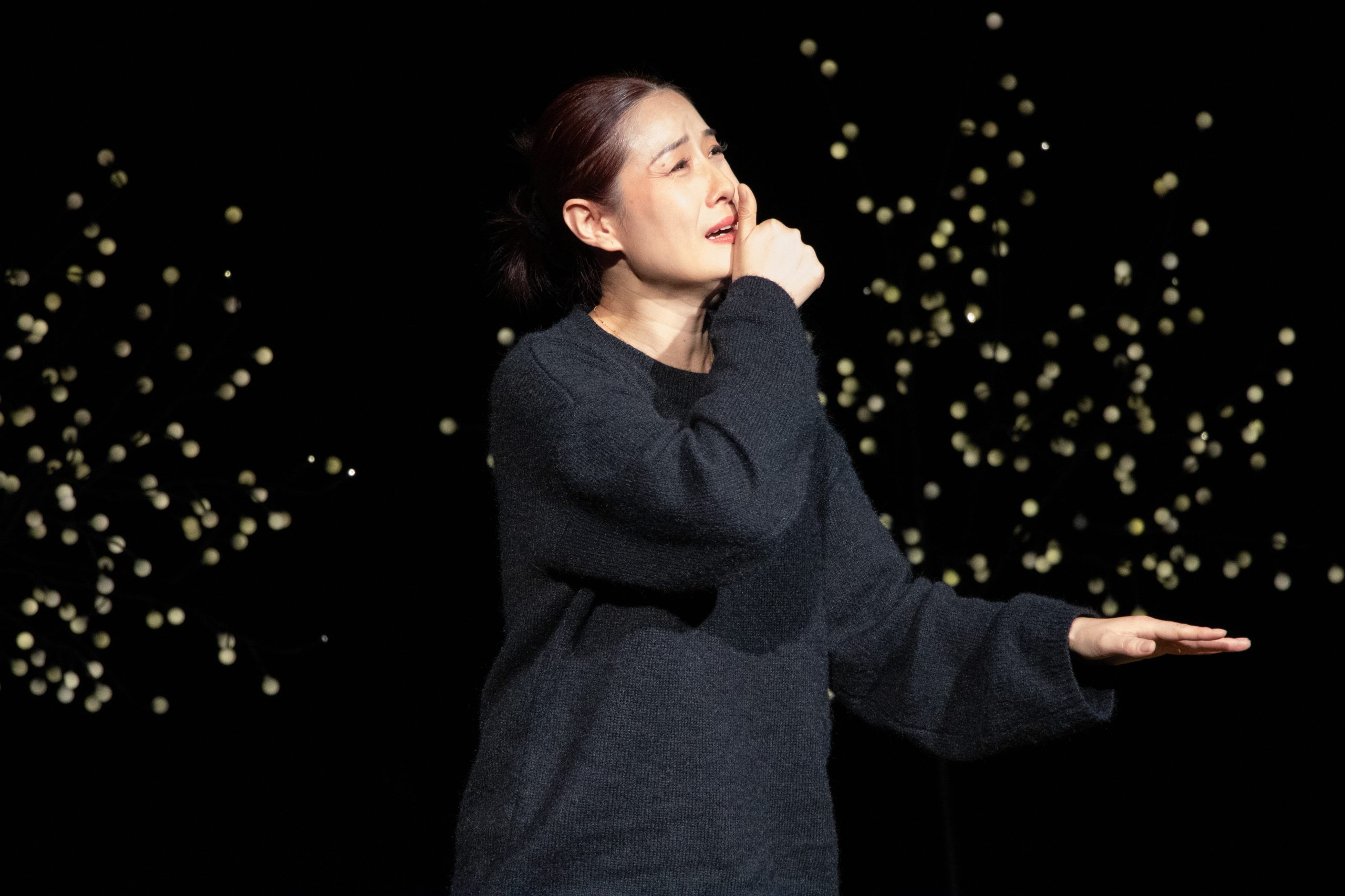 Qi Chunyan från Kina uppträder på scen. Hon tecknar det kinesiska ordet för mamma.